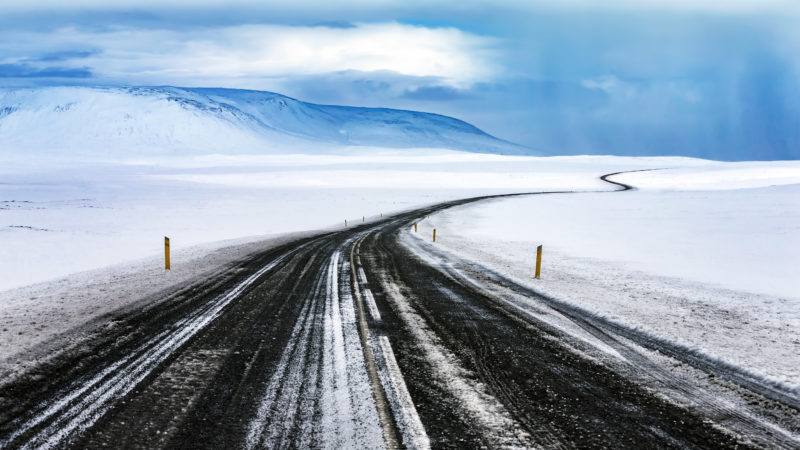 Positive travel Iceland Guide Snowy road, long curved highway among beautiful white snowy landscape, winter travel, beautiful nature of Iceland