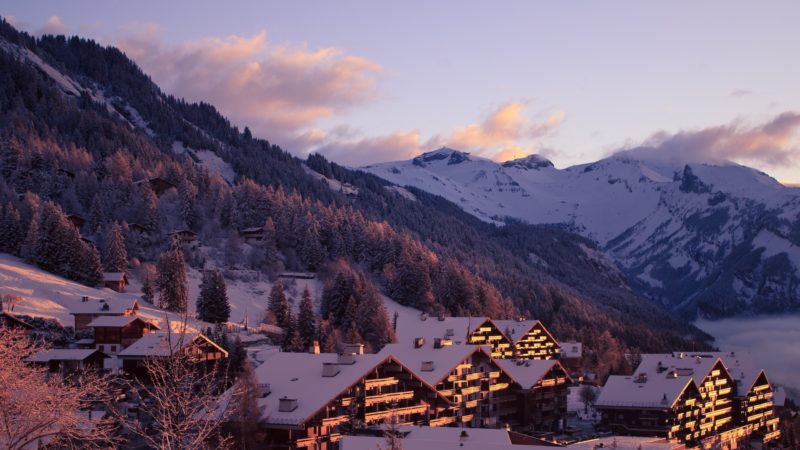 Positive Travel Best Sustainable Ski Resorts in Switzerland Anzère village and mountain winter view at sunset 
