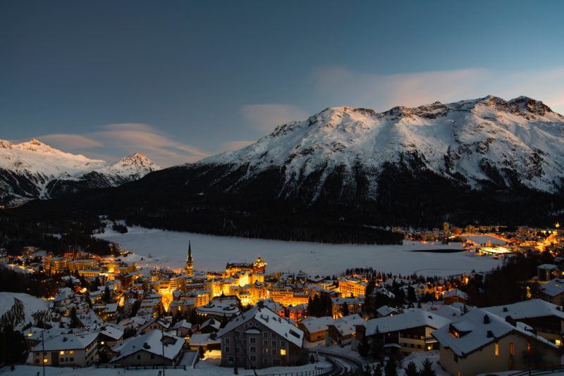 Positive Travel Best Sustainable Ski Resorts in Switzerland St Moritz snow covered village and frozen lake view at sunset